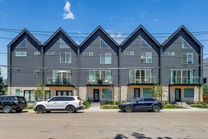 A modern multi-story residential building with a symmetrical facade, large windows, and a central entrance. - Walkable Location: Pet-friendly Denver Townhome (Denver)