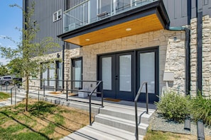 A modern building with a stone facade, large windows, and a wooden overhang.