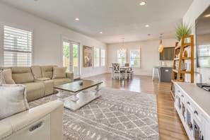 A spacious living room with a sofa, coffee table, and dining area. - Close to Beach! Miramar Beach Haven w/ Pool Access (Miramar Beach)
