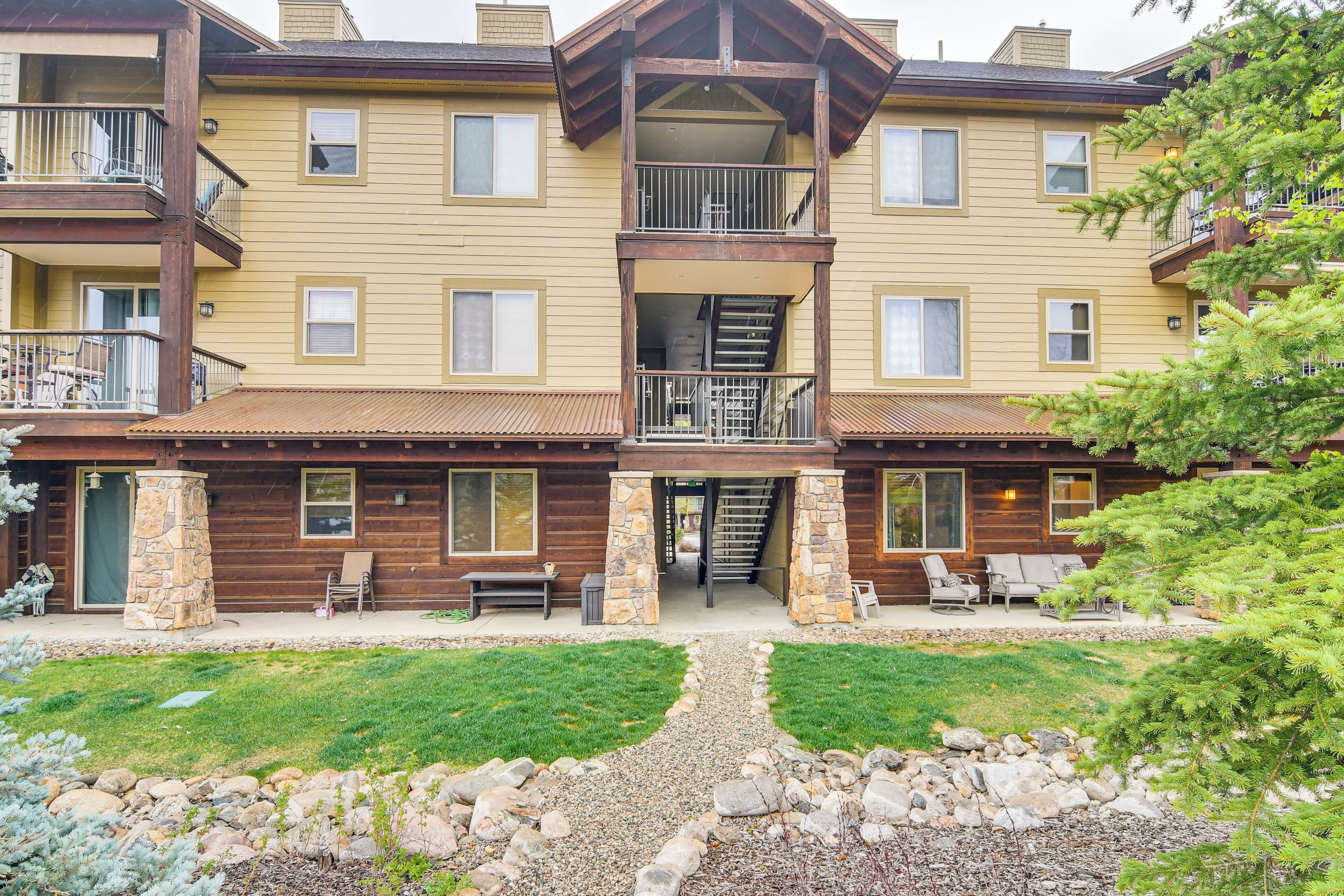 A multi-story building with balconies, a stone pillar, and outdoor seating.
