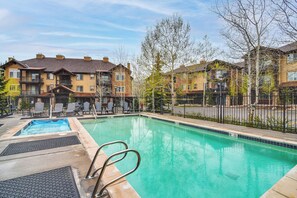 A swimming pool with steps and lounge chairs, surrounded by apartment buildings. - Condo in the Heart of Dtwn Winter Park (Winter Park)