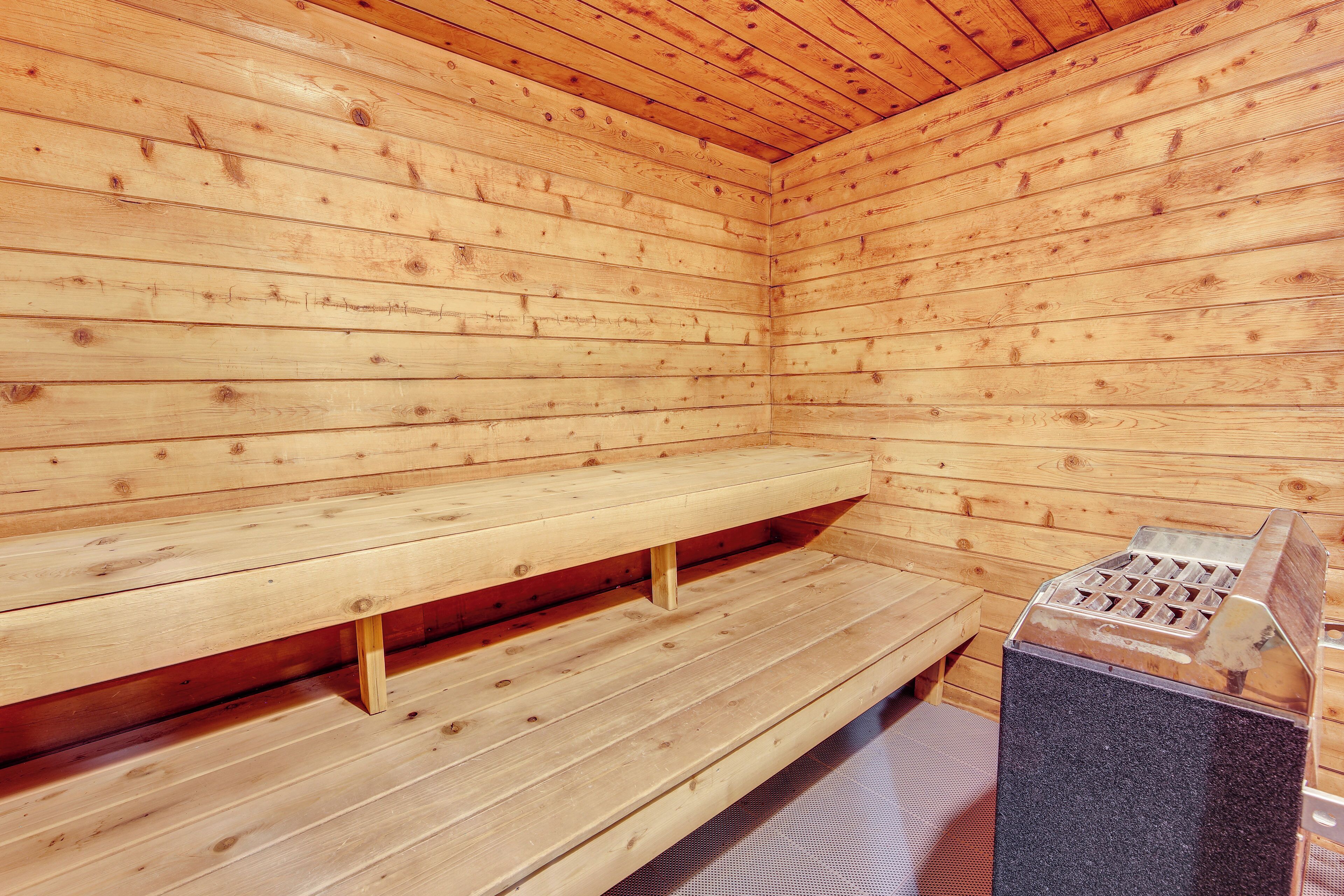 A wooden sauna with benches and a stone bench.