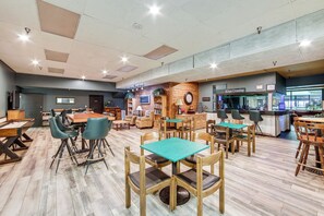 Tilava sisätila, jossa on useita erilaisia istumapaikkoja, palvelutiski ja selkeästi näkyvä opaste, jossa lukee ”Kings Crossing”.