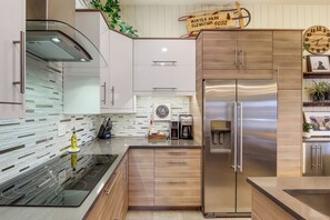 Eine moderne Küche mit einem Edelstahl-Kühlschrank, einem Einbauofen und einer Kaffeemaschine.
