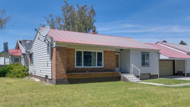 Ein eingeschossiges Haus mit rotem Dach, Backsteinfassade und Satellitenschüssel.