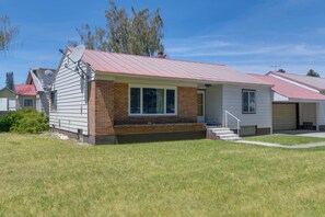 A single-story house with a red roof, a brick section, and a satellite dish.