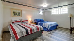 Ein Schlafzimmer mit zwei Betten, einem Bild an der Wand, einem Fenster und einer Lampe.
