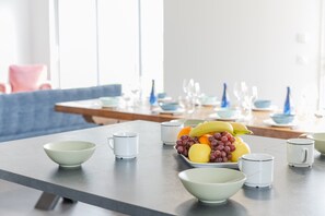A dining table with bowls, a fruit bowl, and white cups. - House in Landunvez Near Penfoul Beach (Landunvez)