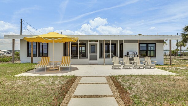 A modern house with a patio, outdoor seating, and a grill. - Casa Del Mare Beach to Bay on Alligator Point (Panacea)