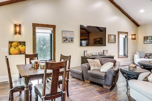 A dining area with a wooden table and chairs, a sofa, and a coffee table. - Roxboro Lake Family Retreat and Spa (Prospect Hill)