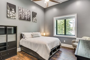 A bedroom with a bed, a dresser, a window, and artwork on the wall. - Roxboro Lake Family Retreat and Spa (Prospect Hill)