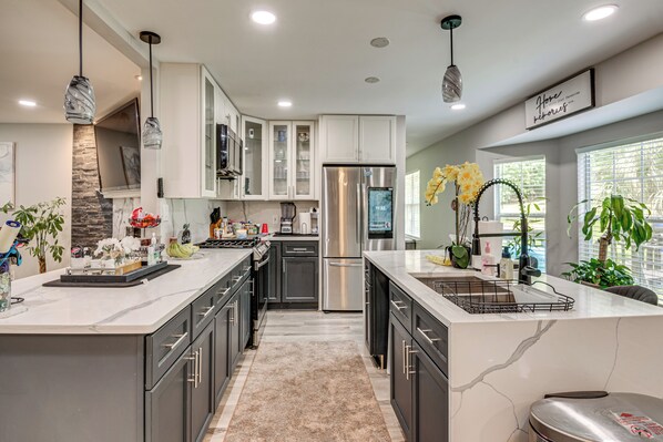A modern kitchen with a central island, stainless steel appliances, and a marble backsplash. - Pool, Hot Tub & Game Room! Stockbridge Oasis (Stockbridge)