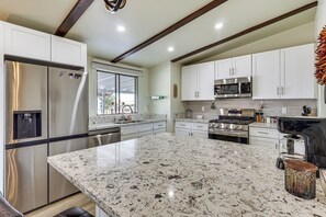A modern kitchen with a large island, stainless steel appliances, and white cabinetry. - 2 Mi to Colorado River! Family Home w/ Fenced Yard (Bullhead City)