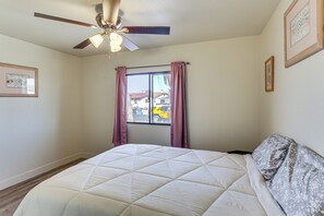 A bedroom with a bed, a ceiling fan, a window with curtains, and framed pictures on the wall. - 2 Mi to Colorado River! Family Home w/ Fenced Yard (Bullhead City)