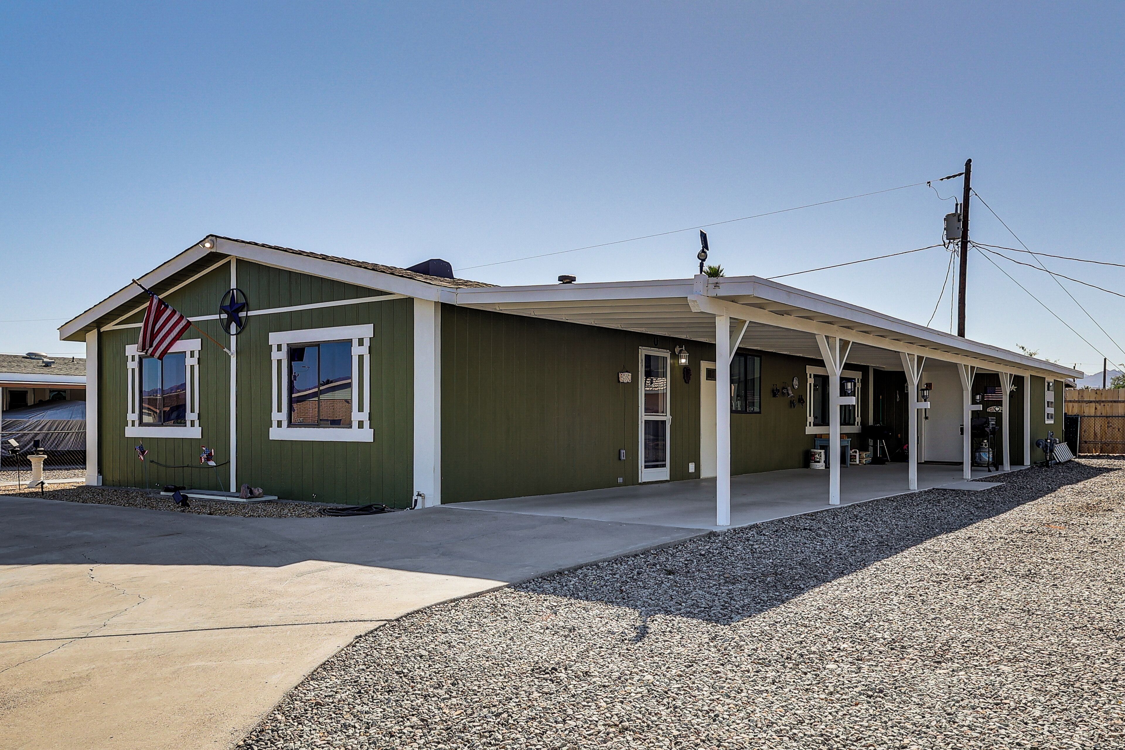 A single-story building with a covered porch, a flag, and a small window.