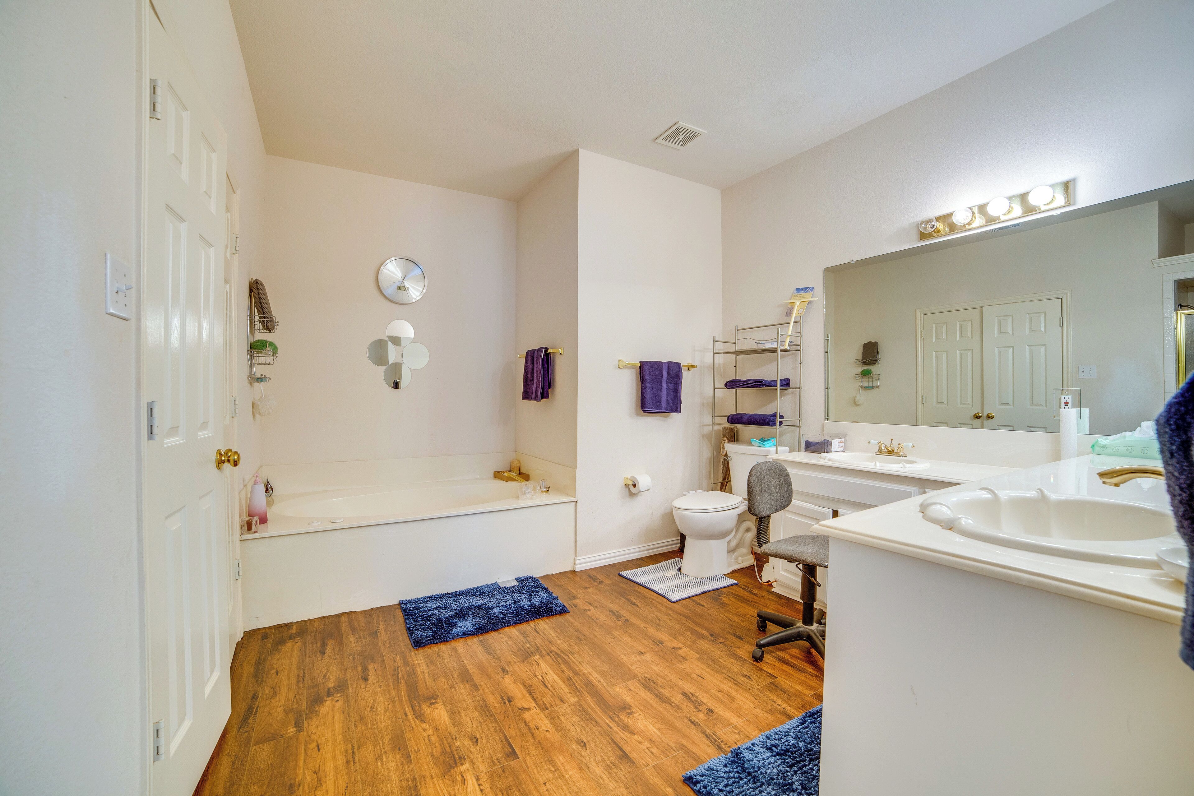 A bathroom with a bathtub, toilet, sink, and mirror.