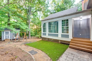 A residential property with a well-maintained lawn, a wooden swing set, and a garage. - Easy Hwy Access to Dtwn Atlanta! Group Retreat (Atlanta)