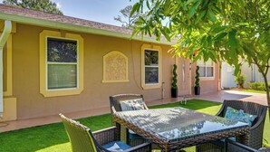 A yellow house with a patio, wicker furniture, and a small lawn. - Golf, Beaches & Sunshine! Pet-friendly Naples Home (Naples)