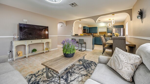 A modern living room with a flat-screen TV, a coffee table, and a sofa. - Golf, Beaches & Sunshine! Pet-friendly Naples Home (Naples)