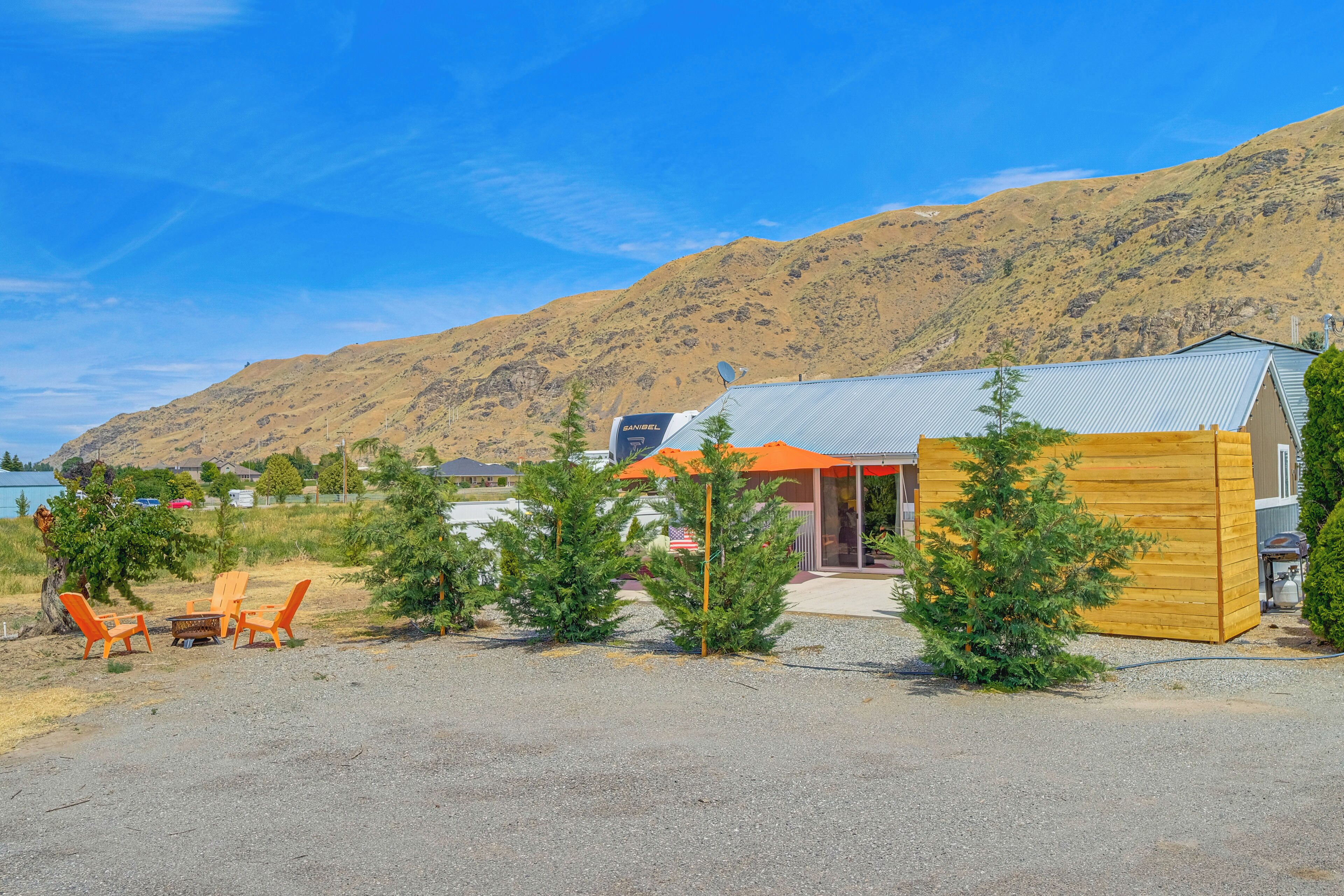 A building with a metal roof, a wooden deck, and a gravel driveway.