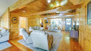 A log cabin interior with a sofa, chairs, a dining table, and a kitchen area. - Pets Welcome! Lakefront Retreat w/ Dock in Newport (Newport)