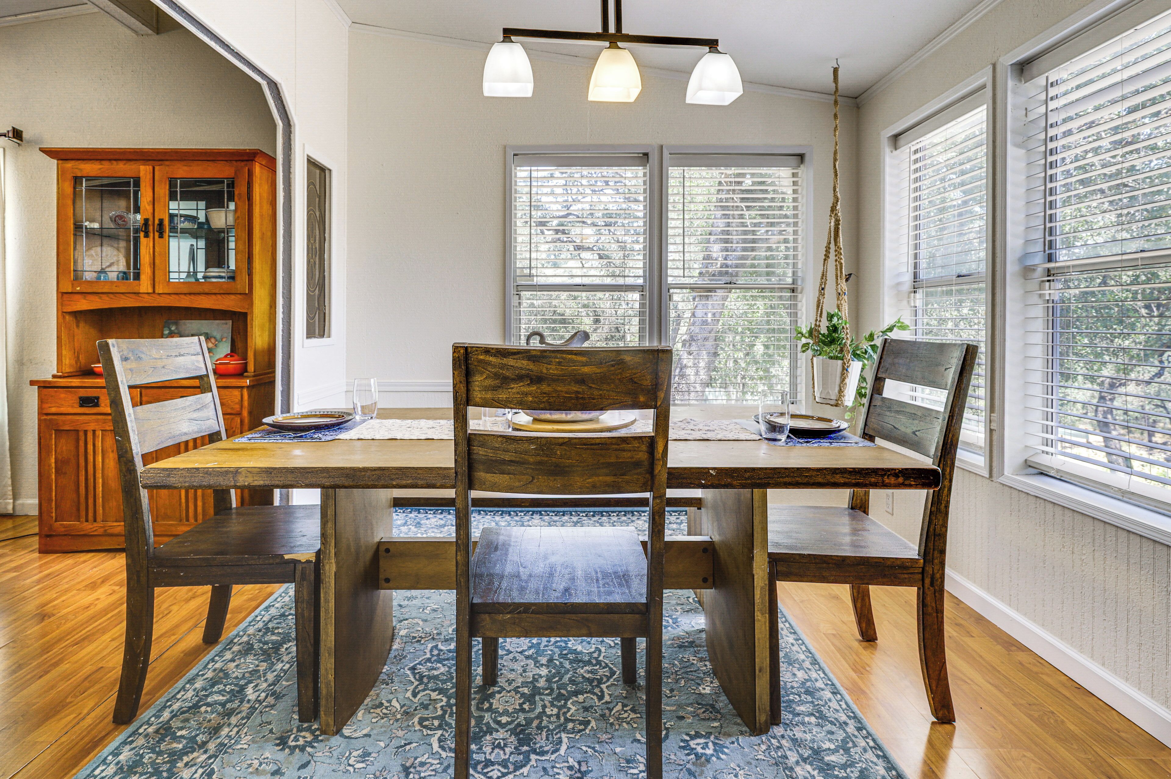 A dining area with a wooden table, chairs, and a rug.