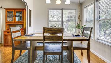 A dining area with a wooden table, chairs, and a rug.