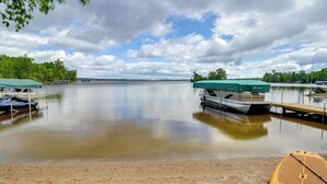 Um lago tranquilo com barcos atracados em cais de madeira, rodeado por árvores.