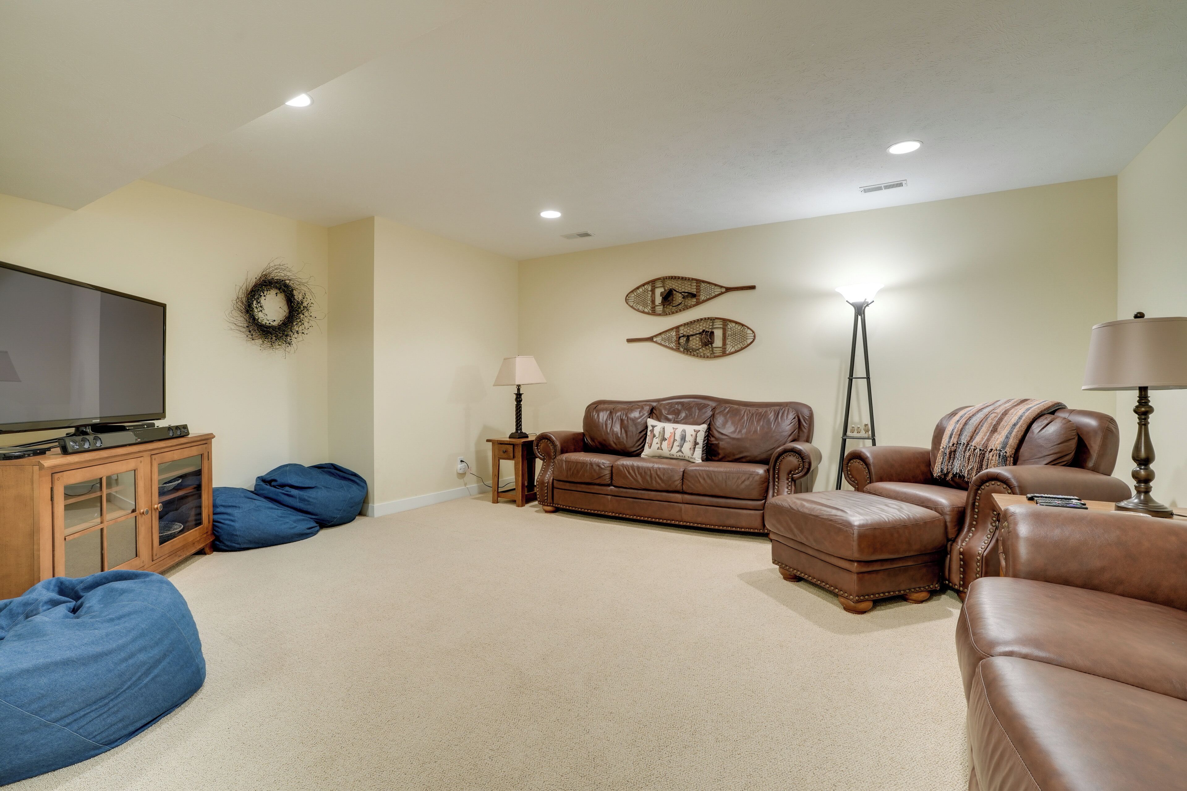 A living room with a television, leather sofas, a coffee table, and a floor lamp.
