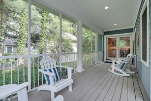 A covered porch with white railings, two Adirondack chairs, and a view of a house and trees. - South Haven Family Lake Getaway 4 Mi to Downtown (South Haven)