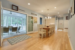 A spacious dining area with a large table and chairs, a ceiling fan, and a view through glass doors to an outdoor patio. - South Haven Family Lake Getaway 4 Mi to Downtown (South Haven)