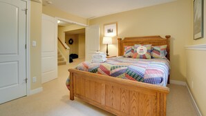 A bedroom with a wooden bed, a quilt, a lamp, and a picture on the wall. - South Haven Family Lake Getaway 4 Mi to Downtown (South Haven)