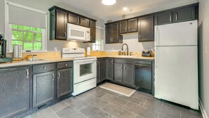 A kitchen with dark wooden cabinets, a white refrigerator, a microwave, and a stove. - Guest House w/ Private Pond & Dock in Southbury! (Southbury)