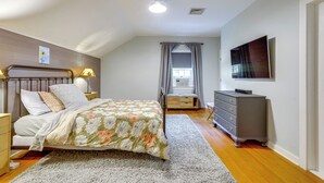 A bedroom with a bed, bedside tables, a dresser, a television, and a window with curtains. - Guest House w/ Private Pond & Dock in Southbury! (Southbury)