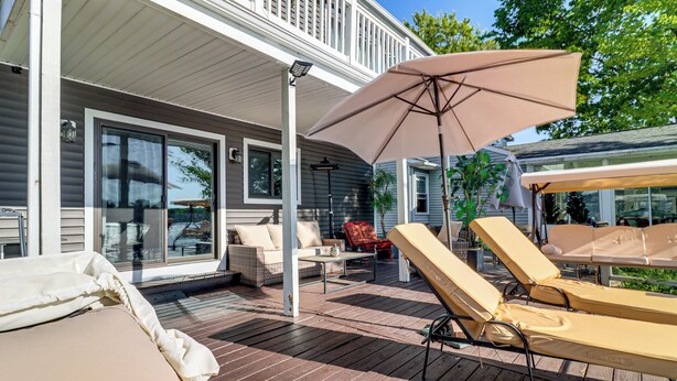 Een terras met lounge fauteuils, een tafel en een parasol.