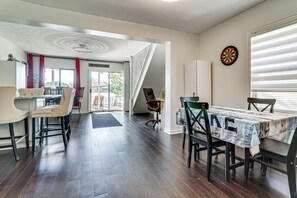 A dining area with a table covered in newspaper, a dartboard on the wall, and a staircase leading to another room. - Private Dock & Boat Slip! Belleville Lake Escape (Belleville)