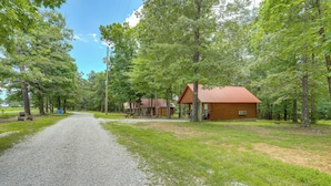 A gravel path leading to a cabin with a red roof, surrounded by trees. - Near Trails! Ozark Mtn Hideaway w/ Fire Pit, Grill (Fifty-Six)