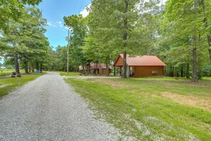 A gravel path leading to a cabin with a red roof, surrounded by trees. - Near Trails! Ozark Mtn Hideaway w/ Fire Pit, Grill (Fifty-Six)