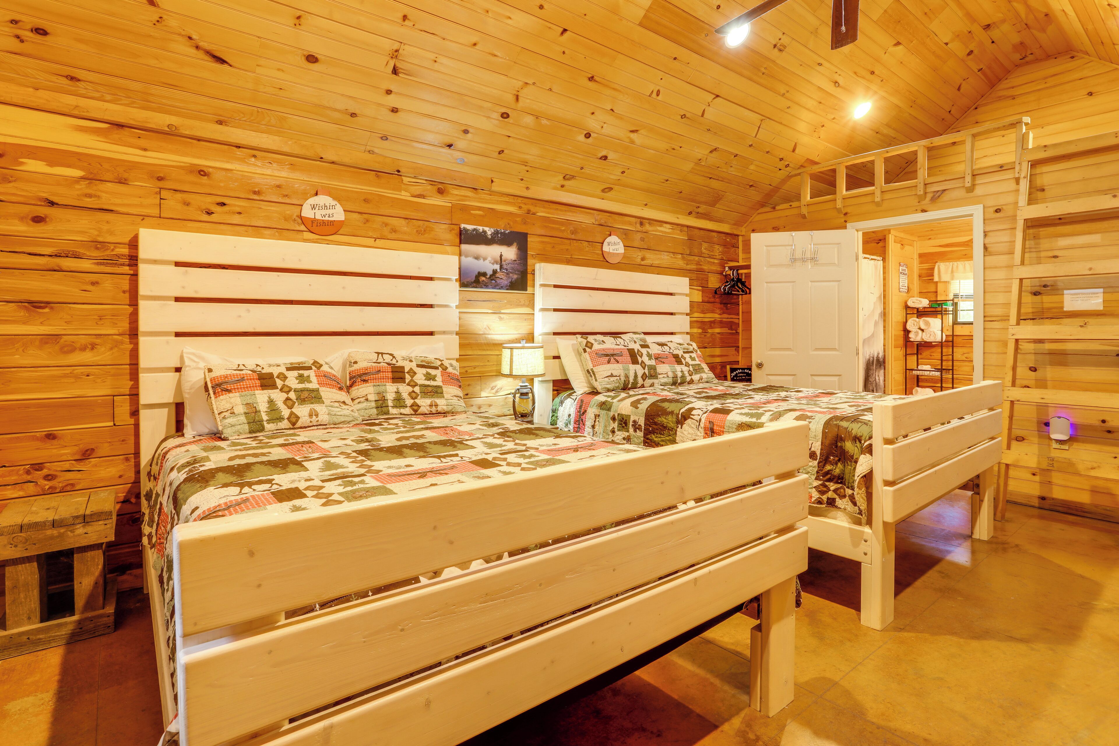 A wooden interior with a bed, a bench, and a door leading to another room.