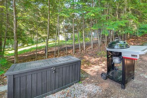 A portable grill with a water feature and a storage unit in a wooded area. - Waterfront Sand Pond Cabin w/ Views & Fire Pit (Litchfield)