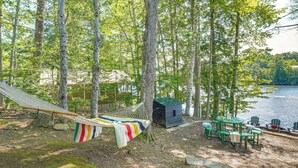 A hammock, a small cabin, and a table with chairs by a lake. - Waterfront Sand Pond Cabin w/ Views & Fire Pit (Litchfield)