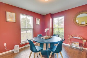 A dining area with a round table, blue chairs, and a vase of flowers. - Pet-friendly Home w/ Private Yard Near Pittsburgh (Clairton)