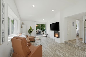 A modern living room with a fireplace, leather sofa, and a TV.
