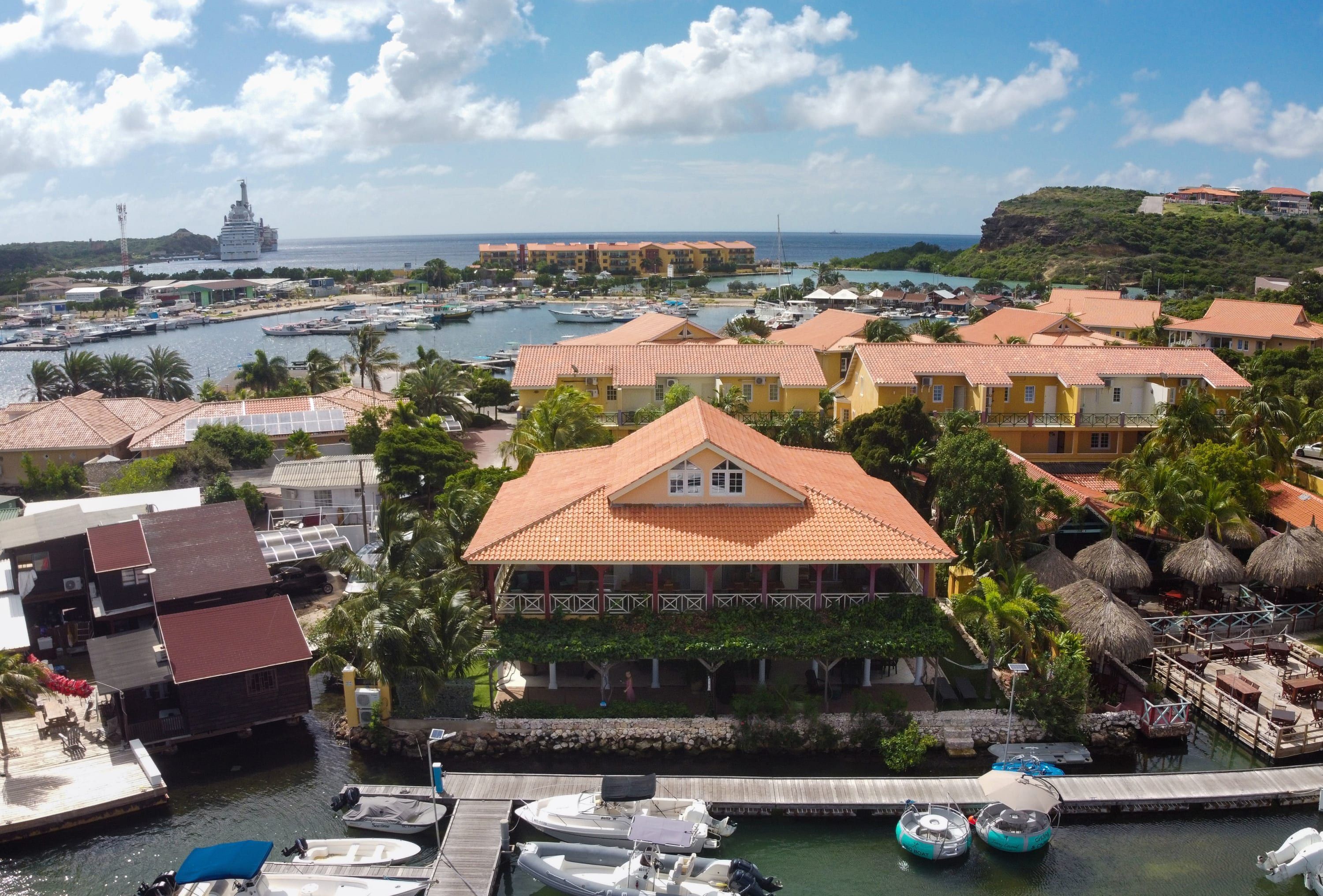 Un hotel frente al mar con un muelle, barcos y vistas al océano.