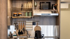 Una kitchenette compacta con microondas, tostadora y refrigerador pequeño.