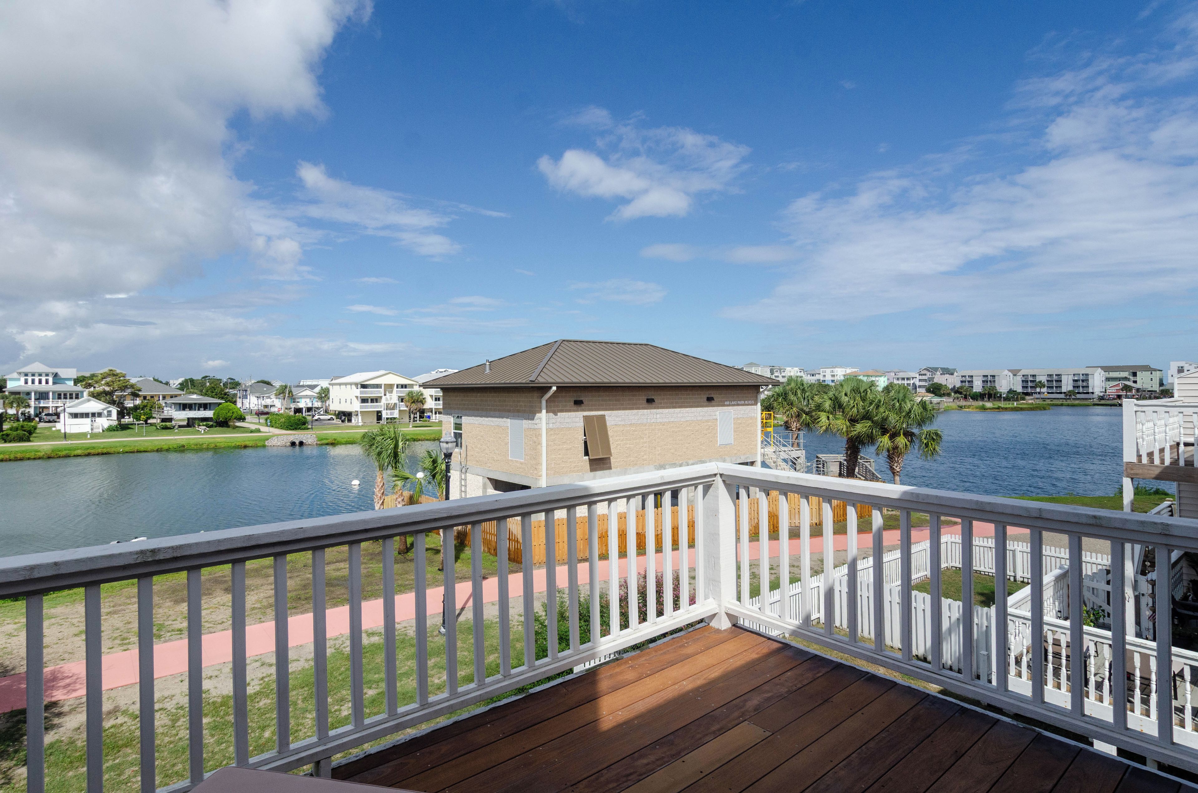 A waterfront property with a wooden deck, a small building, and a lake view.