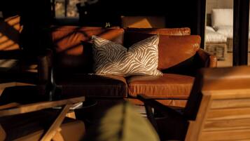 A leather sofa with a zebra-patterned pillow in a dimly lit room.
