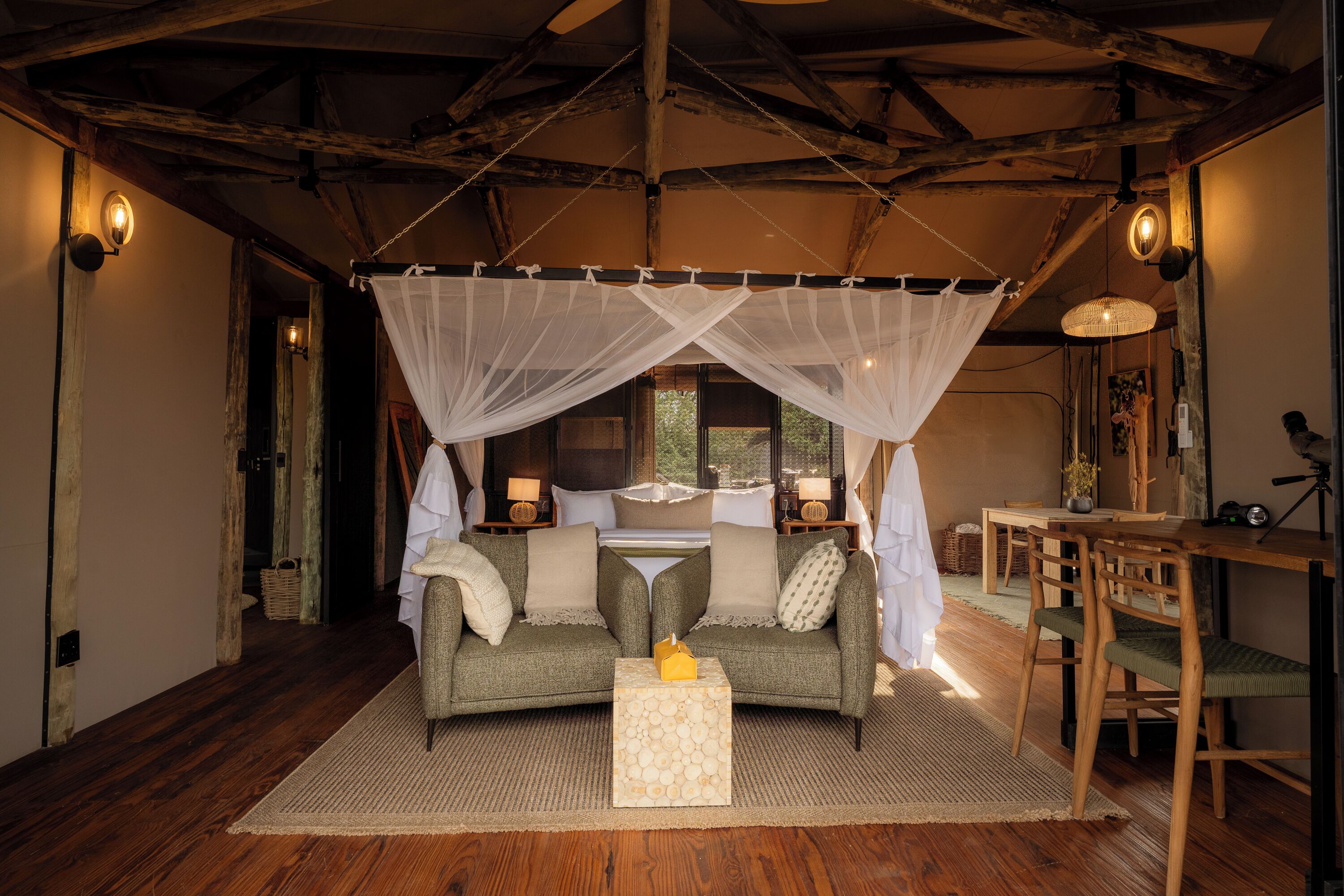 A cozy room with a bed, a sofa, a small table, and a dining area.