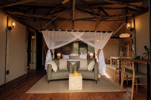 A cozy room with a bed, a sofa, a small table, and a dining area. - Kuona Serengeti (Serengeti)