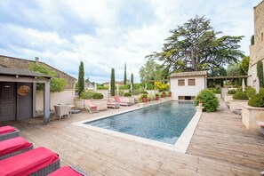 Una piscina amb gandules i plantes en testos.